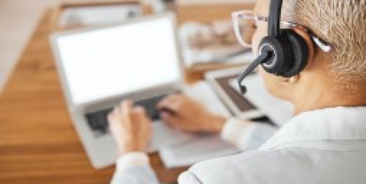 Individual with headset on while using laptop